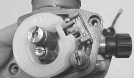 - Remove the carburettor float chamber securing screws and the