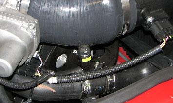 Use a 10mm socket to remove the passenger side fender bolt, install the ground strap ring connector underneath it then