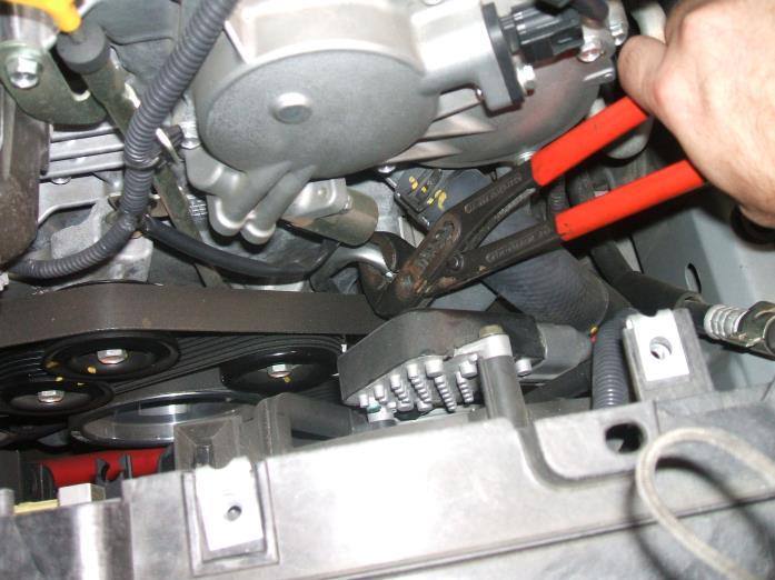 Using a 3/8 drive ratchet, release the tension from the drive belt and insert an Allen wrench or bolt into the