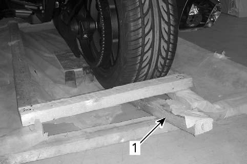 Remove the piece of wood at the back of the crate and insert it under the rear wheel.