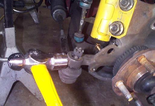20. Free the tie-rod end by hitting the front end of the steering arm with a large hammer.