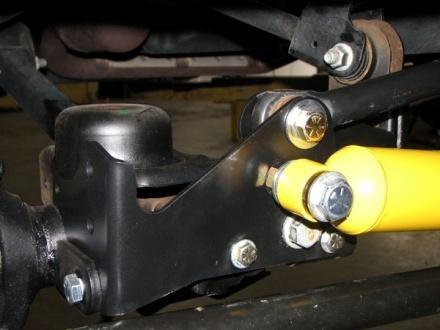 13-1 13-2 Once the axle-end is secure, place one washer on the stud of the tie-rod mount you loosened and moved earlier (this acts as a spacer for clearance), the put the damper onto the stud and add