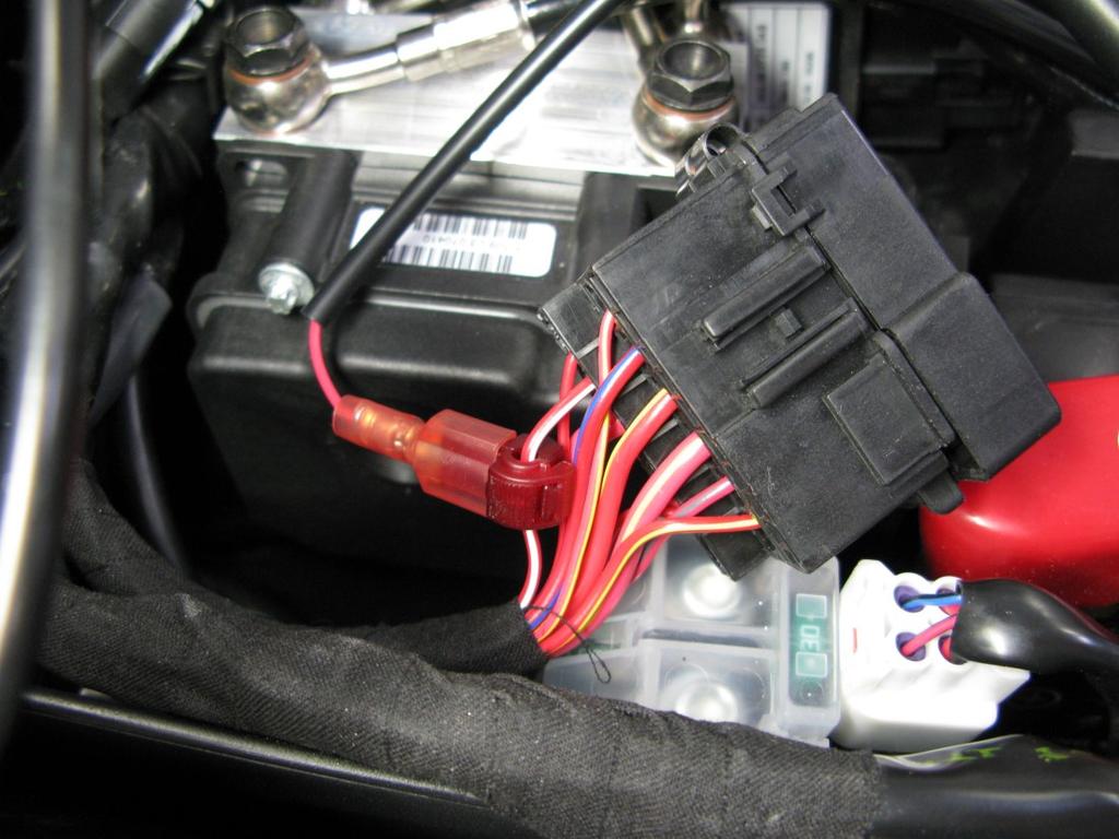 2. Locate the factory fuse box beneath the rider seat. Locate the factory red/white wire which goes to the alarm.