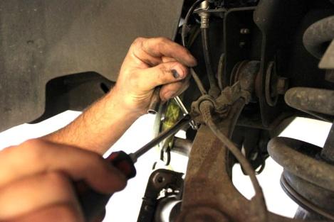 Open up brake hose clamp on upper control