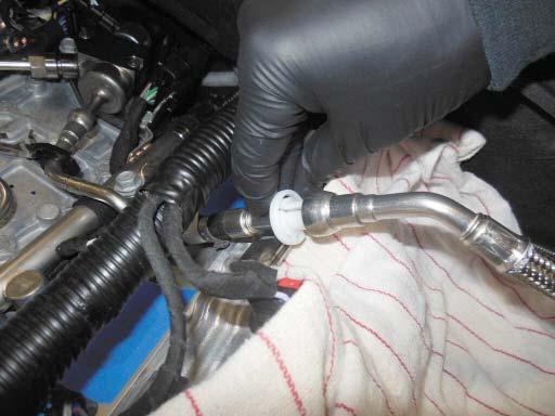 41. Place the plastic tool provided over the fuel line at the location shown.