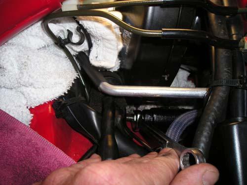 8. Install blue hose to brake fluid reservoir. Be careful not to over-tighten and break the plastic nipple. 9. Now get back under the dash to install the clevis bolt, plastic bushing and spring clip.