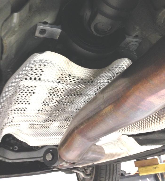 6. With the heat shield out of the car, remove the two bolts for the center support