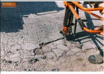 Blow high pressure air into the pothole to dry and clean the damaged area and ensure a good patch.