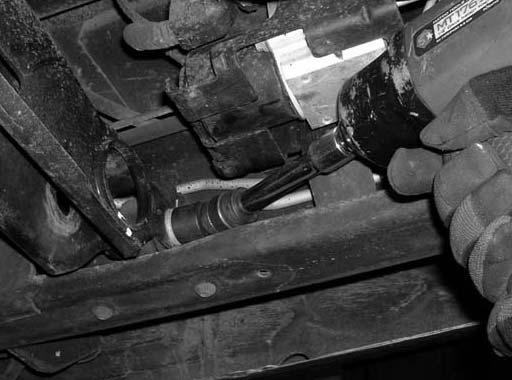 Working on the driver side, attach the torsion bar removing tool to the stock torsion bar cross member, making sure that the unloading bolt in the center of the torsion bar removing tool is in the