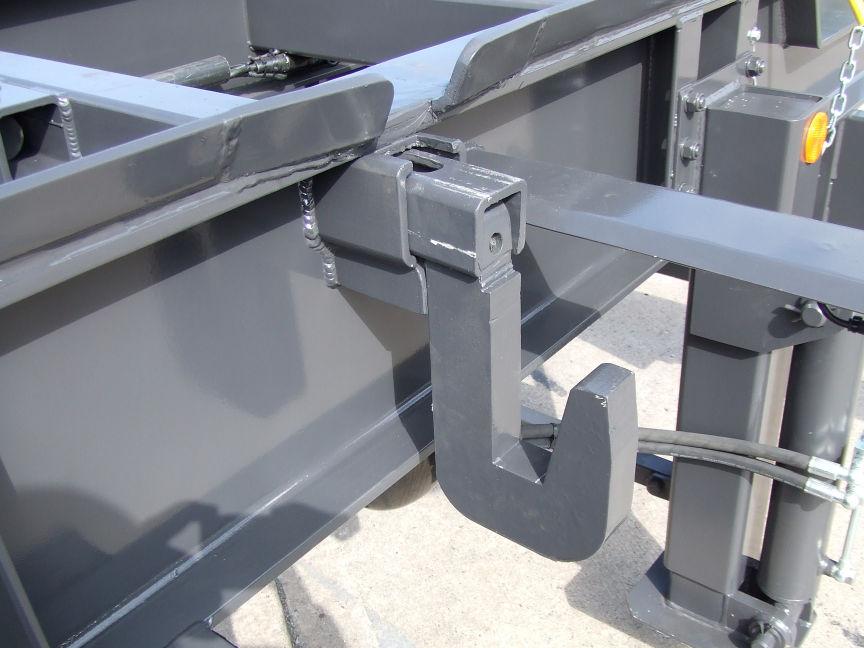 ) Using the lever, open the four hydraulic container clamps on the trailer. Ensure the contact area between the container and trailer is adequately lubricated.