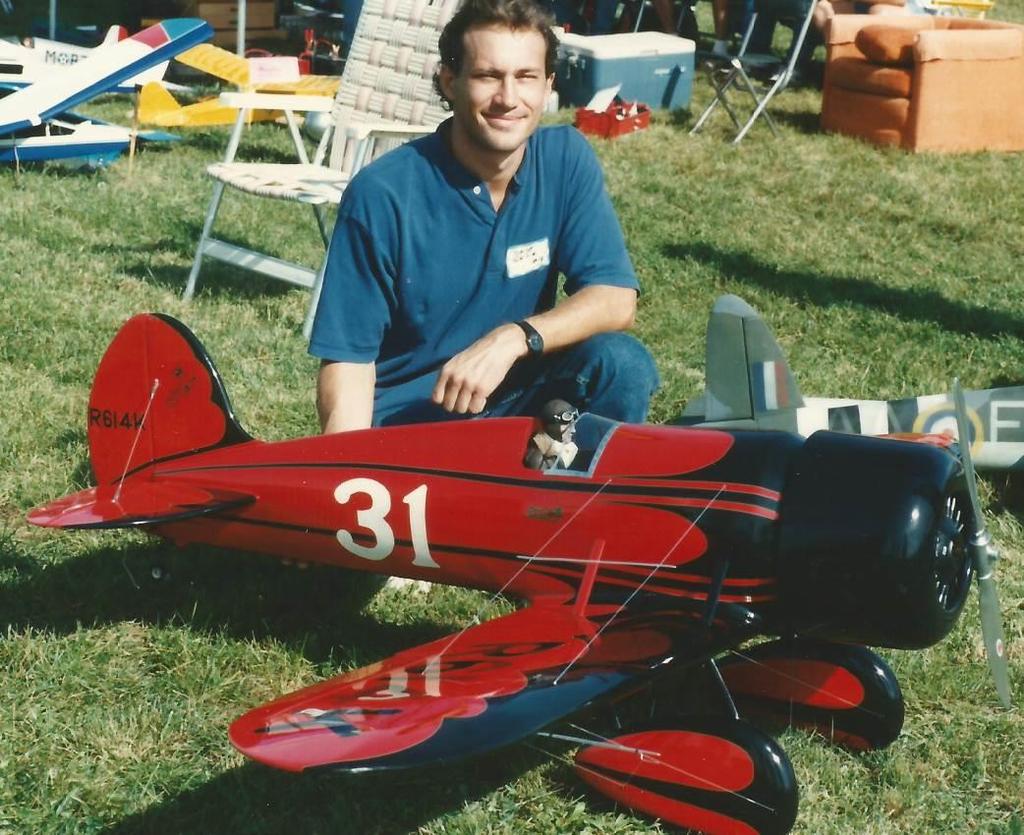 Dave Grife with his Travel Air Mystery Ship This beautiful Thompson Trophy Racer mounts a geared Astro Cobalt 90 motor running on 36 Nicad cells and spins a 22x14 prop at 4,700 Rpm.