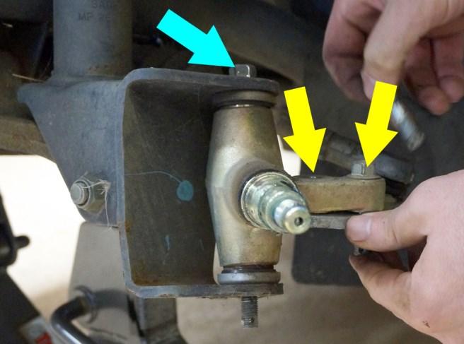 Disconnect the steering knuckles from the spindles by removing the safety pins,