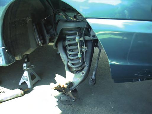Carefully lower the control arm with the jack and remove the spring. If necessary, use a spring compressor.