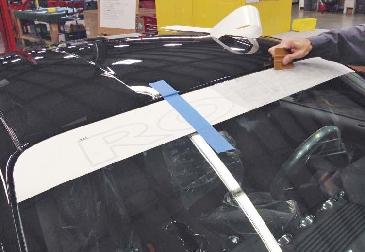 5. Peel the protective covering off of the applied portion of the windshield banner up toward