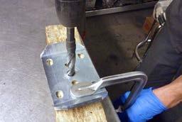 Tech Tip 76 This shows the center hole of the U-bolt plate being enlarged using a drill press and a vice.