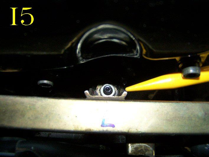 Use a 10mm socket to remove the two nuts that hold the fuel rail down to the manifold. These nuts are located behind the fuel rail on the intake manifold side.