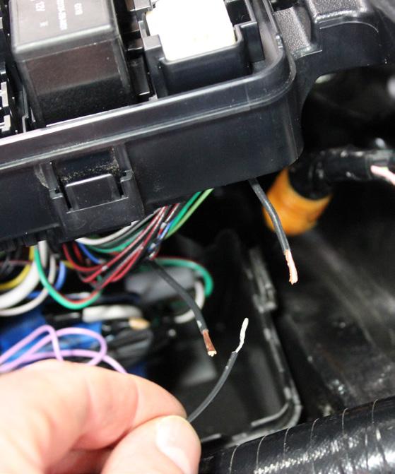 8. Locate the black wire under the fuse panel shown here.