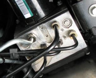 See Photo 1 below for location of line in master cylinder. Photo 1: Location of Front Brake Line on Master Cylinder 4.