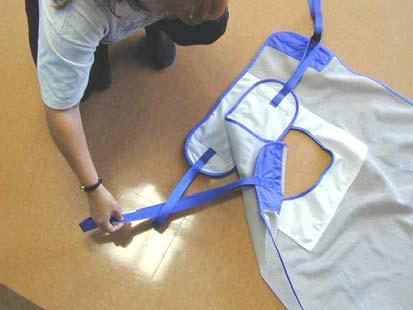 a) Slide the sling end with the white fabric so that it is all the way under both legs. One sling strap will be on top of the other.