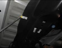 Using a flat blade screwdriver, relocate the OEM strap clip nut located on the rear cross member to the position shown below.