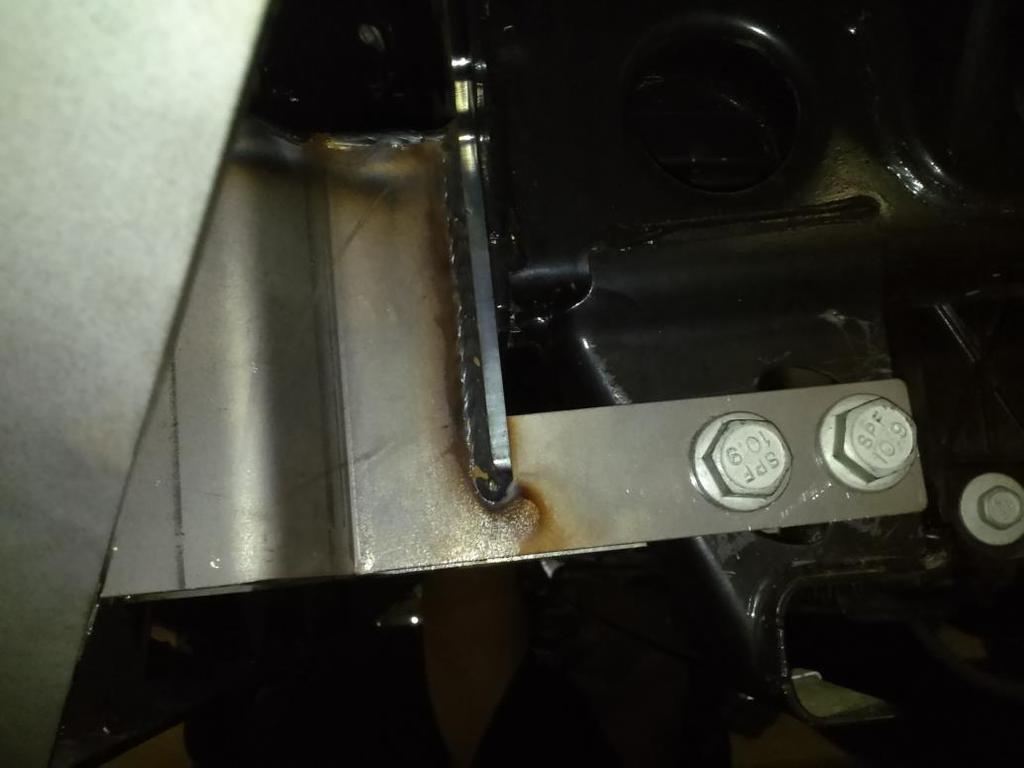 Figure 13b (bracket mounted to frame) C. Taking care to not hit the bottom of the grill. Mount bumper to bracket with the help of at least 2 others and a jack.