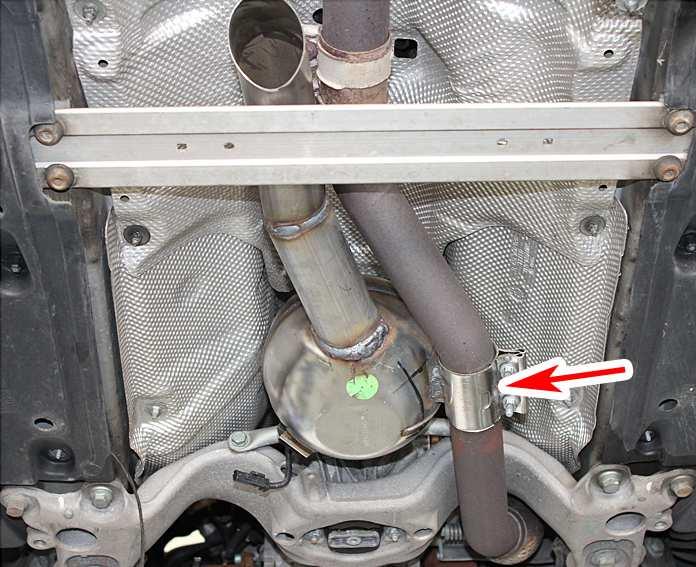 Take an angle grinder and cut the exhaust pipe at the marked (arrow) position, Fig. 14.
