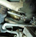 Using a straight screw driver or a pry bar, pry the linkage rod from the floor shifter assembly.