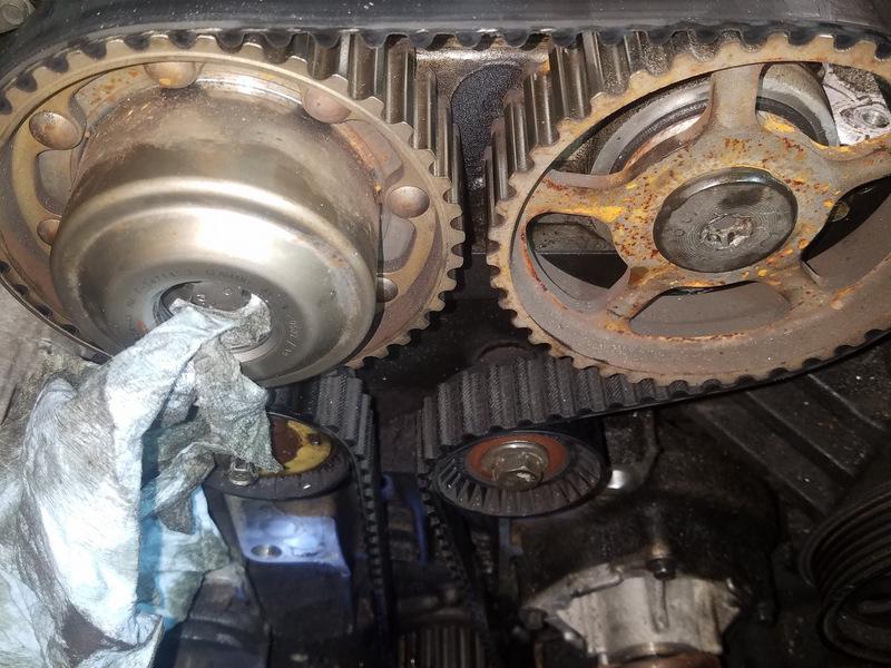 Step 24 Loosening the Crankshaft Sprockets Part 2 After all of the oil is drained, loosen the E18 bolt holding the intake sprocket in place while holding the camshaft with a proper open end wrench
