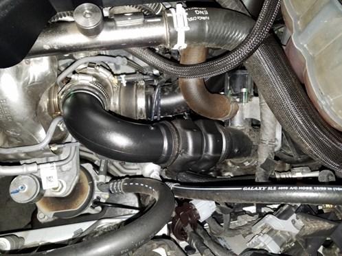 You can now access the intercooler hose connectors from the bottom. Loosen the hose clamps on the intercooler side and slide the hose connectors rearward.