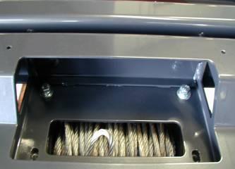 Place the winch on a table with the feet facing up and using an assistant, carefully lift the bar on top of the winch. 5.