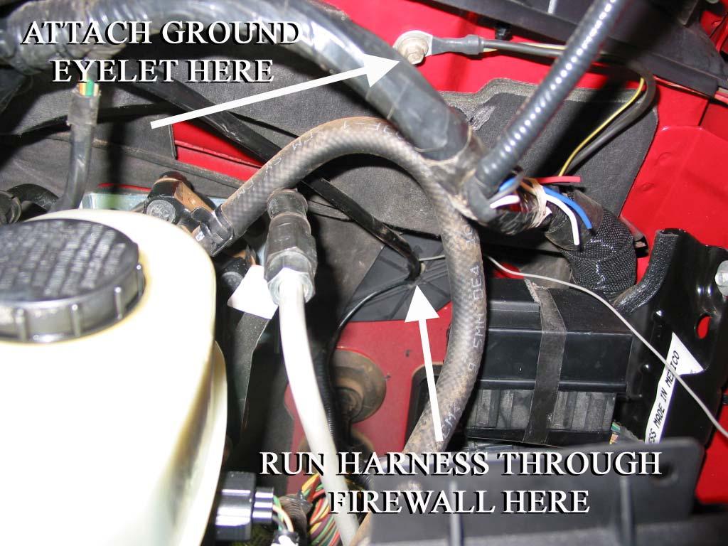 Connect the ground eyelet to this grounding point in the engine compartment.
