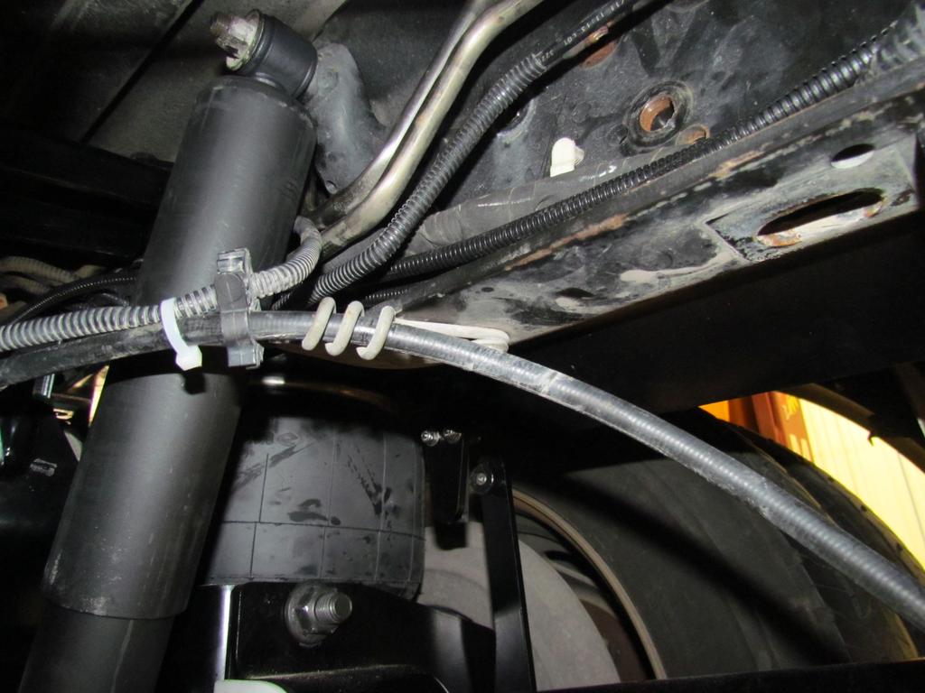 4. Locate and reposition Brake Cable Holder on under-side of driver side frame rail, as