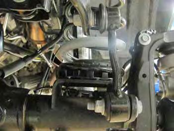 Support the front axle with a hydraulic jack. Remove the lower front shocks mounting bolts (18mm). Save lower hardware. Lower the front axle and remove the coil springs.
