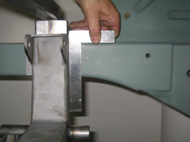 Use a sturdy flat cross bar (approximately 32 long) and a long c- clamp to pull the cross member up tight against