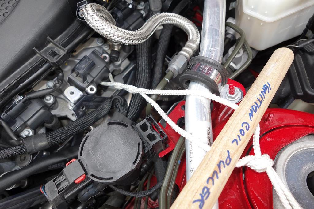 17. Using the handmade puller, wrap the nylon cord around the base of the ignition coil