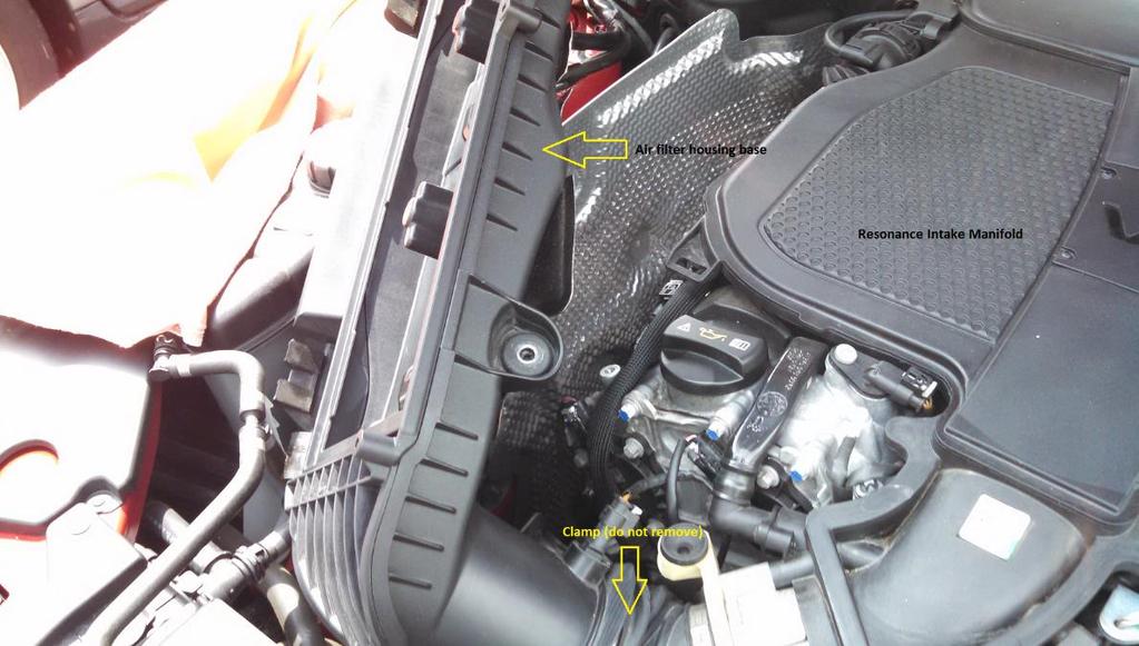 Carefully move the air filter housing out of the way of the ignition coils by gently moving the housing towards the front of the engine.