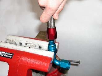 Use motor oil to lubricate the inside and cut end of the hose. Place the blue nipple in a vise.