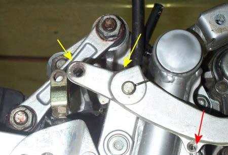 The bolt is indicated in the top picture with a white arrow, and the pin by a yellow arrow in the bottom picture.
