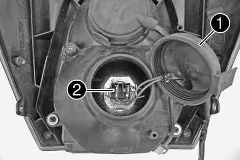 ELECTRICAL SYSTEM 135 Remove rubber cap and connector from the bulb. 100592-10 Detach spring bar and remove the bulb from the headlight.