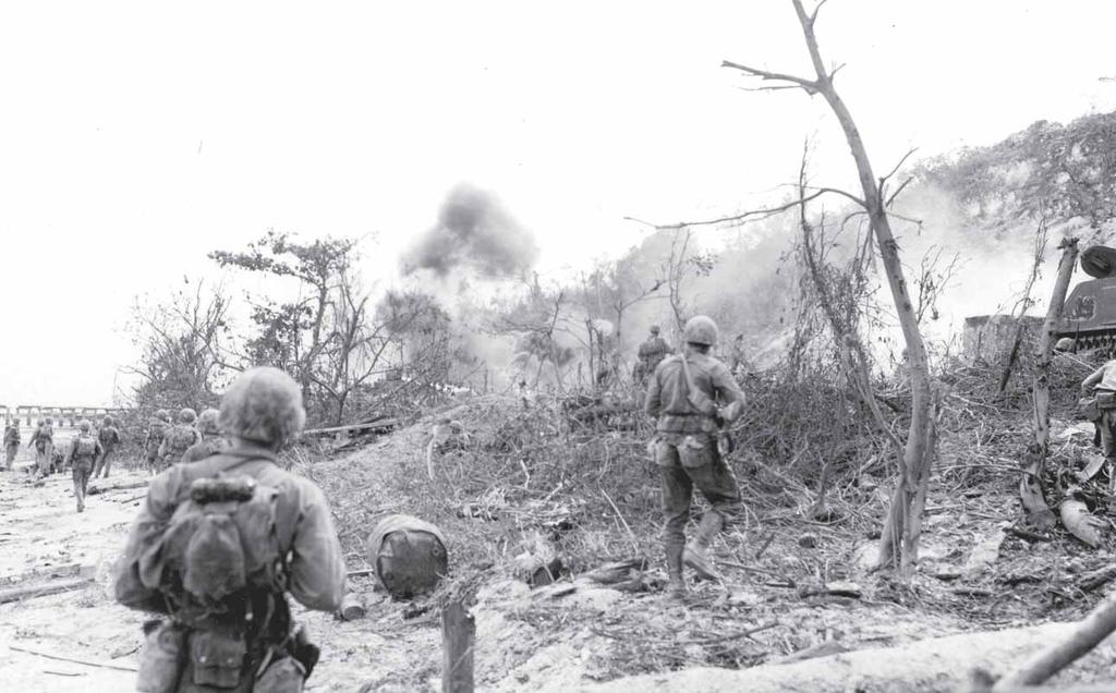 As Marines approach a beach, a tank pummels a Japanese position the