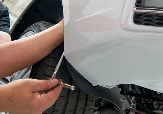 Hold them in this position with one hand as you tighten the front fender bolt and the two nuts on the plastic retainer bracket. Plug in the fog lamps.
