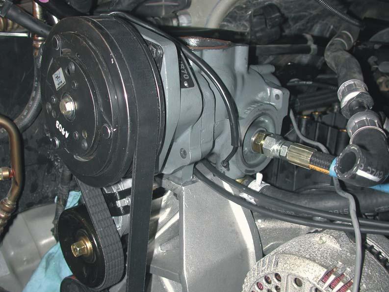 4. Make sure that the cruise control and throttle cables are routed under the compressor body and are not trapped between the compressor and the bracket or other objects (Figure 3.4). Figure 3.