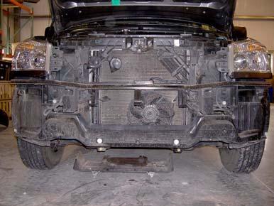 d. Pull driver and passenger wheel well back and remove four bolts from front bumper fascia and
