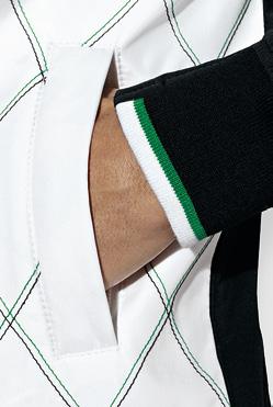 The stand-up collar has a ribbed lining with contrasting stripes, echoing the design of the ribbed cuffs.