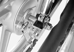 Install the both adjusters and adjuster plates to the swingarm. Insert the axle from the left side through the swingarm, collar and rear wheel. Install the axle nut and washer.