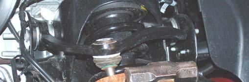 10. Remove the axle nut using a 13mm socket. Retain hardware for reuse. See Photo 7. 11. Loosen the upper ball joint nut using a 21mm wrench.