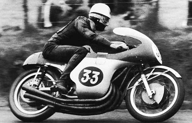 Surtees pioneered a new cornering style to suit the MV four; hanging inside the bike to keep it more upright and prevent the wide engine grounding, while introducing controlled rear wheel drift.