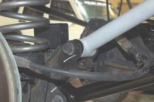 9. Remove upper track bar bolt using 21mm wrench. See Photo 7. 10. Remove the vent hose from the frame. 11. Remove coil springs. See Photo 8.