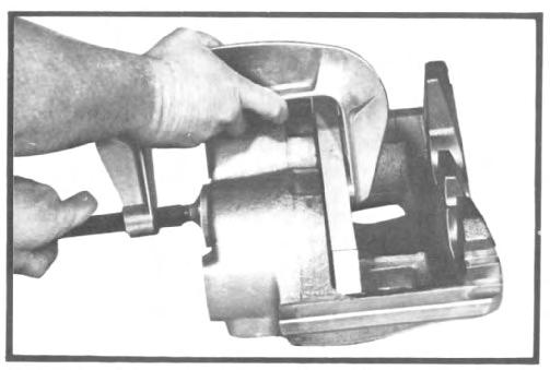 If evidence of fluid leak is noted, the caliper should be overhauled. Fig. 27 Pushing pistons back into caliper.