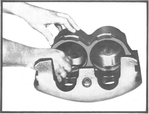 (4) Install caliper assembly over the hub and rotor and position into grooves in torque plate. (5) Install the caliper hold-down assemblies and tighten bolts to 40-ft-lbs. torque. (Fig.